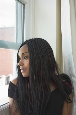 Beautiful black woman gazing out of window clipart