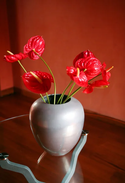 Rode bloemen op glazen tafel — Stockfoto