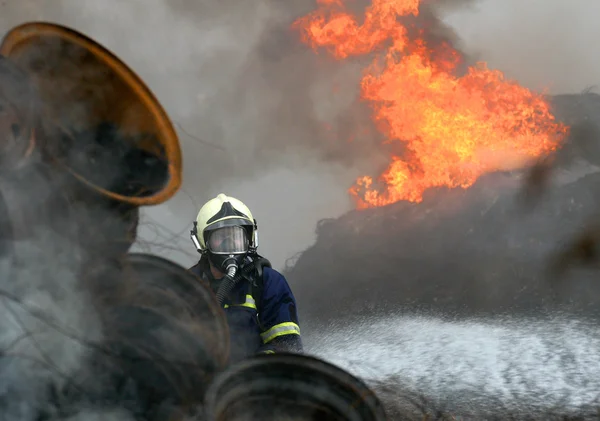 A fireman estinguishing fire of tyres — Stock Photo, Image