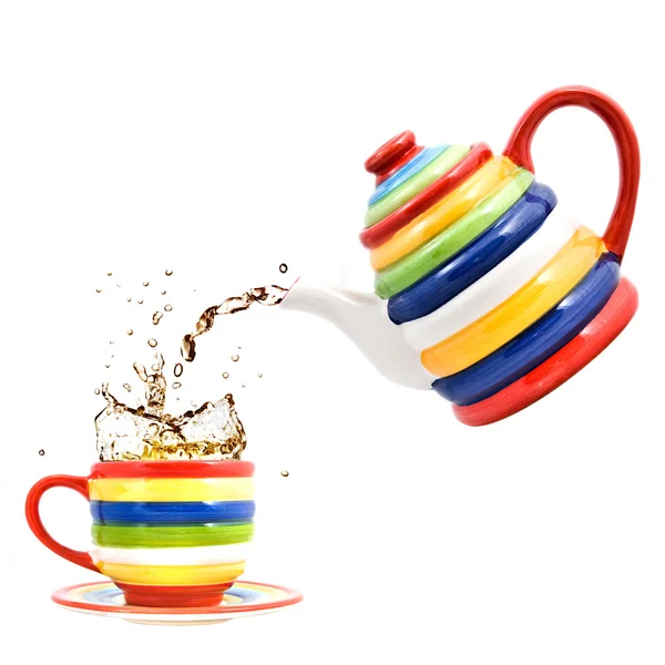 Color teapot with cup and splash of tea — Stockfoto