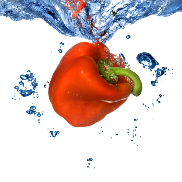 Κόκκινη πιπεριά έπεσε στο μπλε νερό — Φωτογραφία Αρχείου