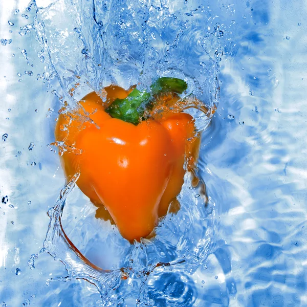 Yellow pepper dropped into water — Stockfoto