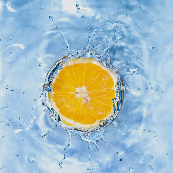 Fresh lemon dropped into water — Stock Photo, Image