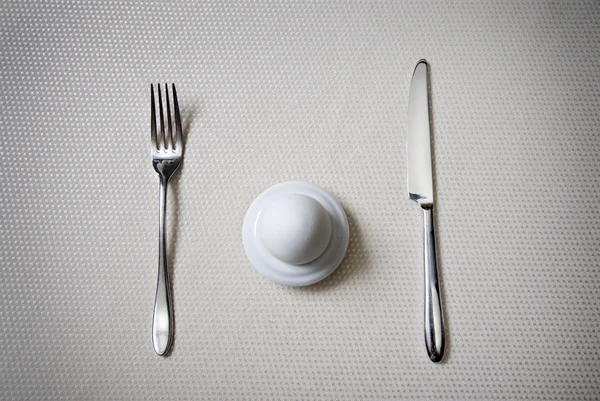 Un huevo con cuchillo y tenedor — Foto de Stock