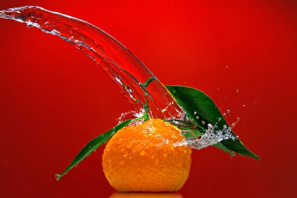 Tangerine with green leaves and water — Stock Photo, Image