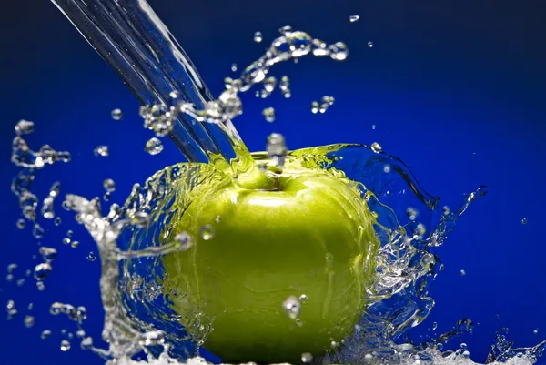 Maçã verde com salpicos de água — Fotografia de Stock