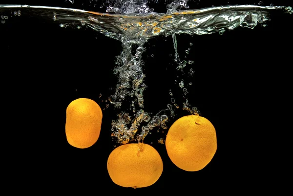 Świeże mandarynki spadł do wody — Zdjęcie stockowe
