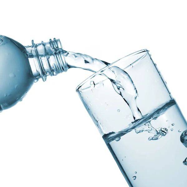Wasser aus der Flasche ins Glas gießen — Stockfoto