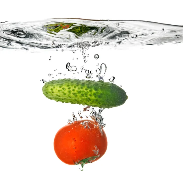 Tomato and cucumber dropped into water — Stock Photo, Image