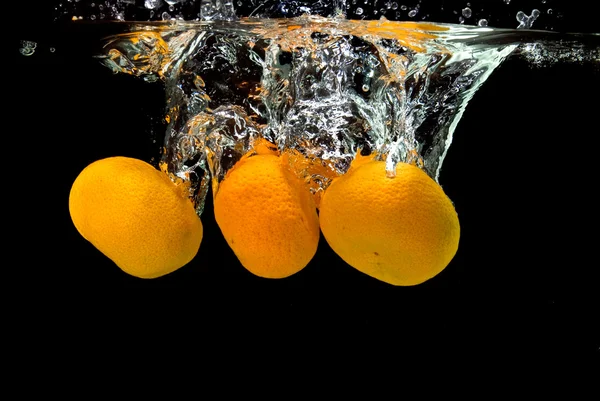 Las mandarinas frescas cayeron al agua — Foto de Stock