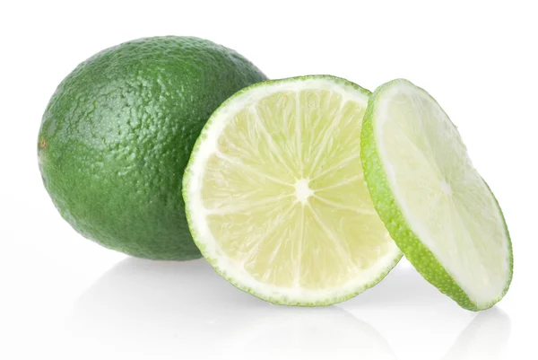 Zielone limonki z plastrami na biały — Zdjęcie stockowe