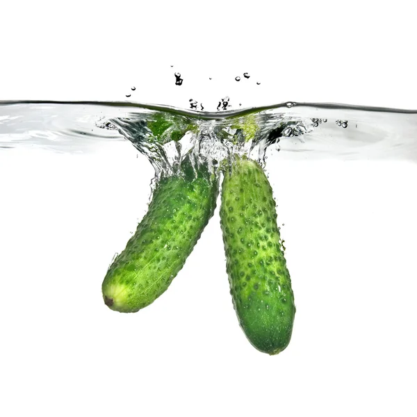 Green cucumbers dropped into water — Stock Photo, Image