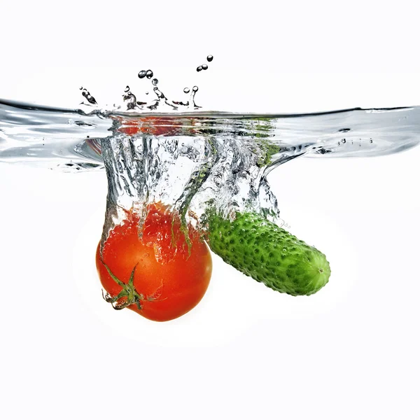 Red tomato and green cucumber in water — Stock Photo, Image