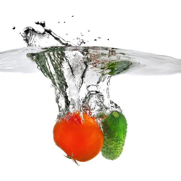 Červené rajče a zelené okurky ve vodě — Stock fotografie