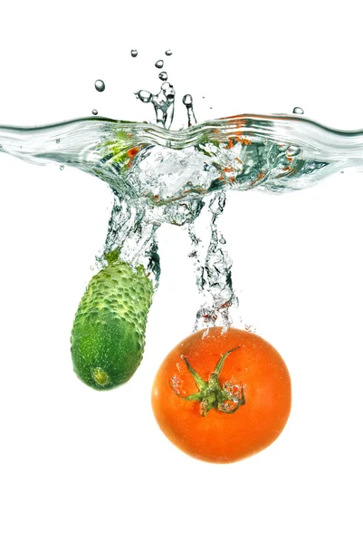 Rode tomaten en groene komkommer in water — Stockfoto