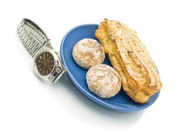 Обед - часы и вкусная выпечка — стоковое фото