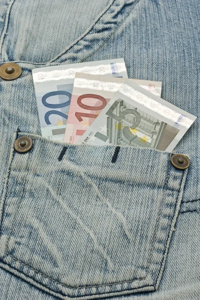 Banconote in euro e jeans usurati — Foto Stock