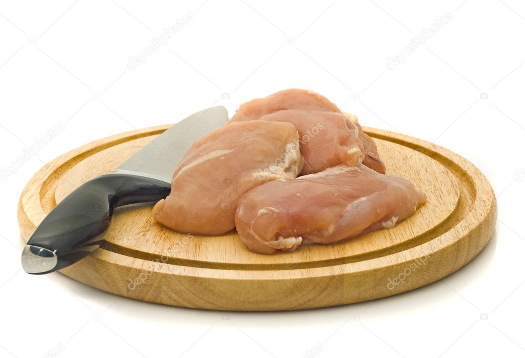 Chicken fillet and knife on hardboard