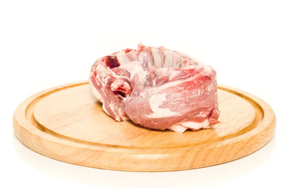 Uncooked pork meat on round hardboard — Stock Photo, Image