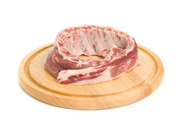 Uncooked Pork meat on round hardboard — Stock Photo, Image