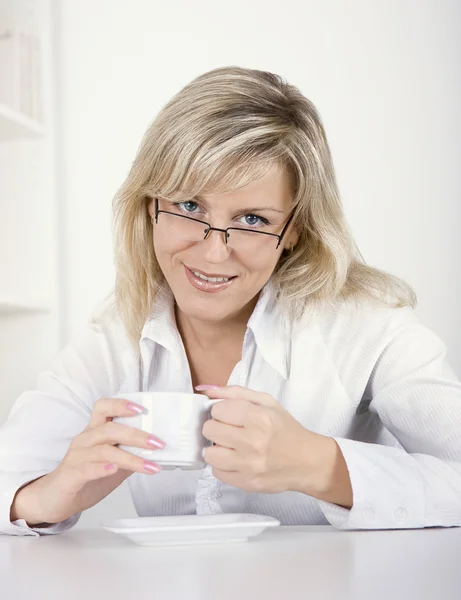 Молода жінка п'є чай або каву — стокове фото