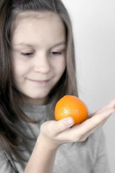 The girl and a tangerine — Stock Photo, Image