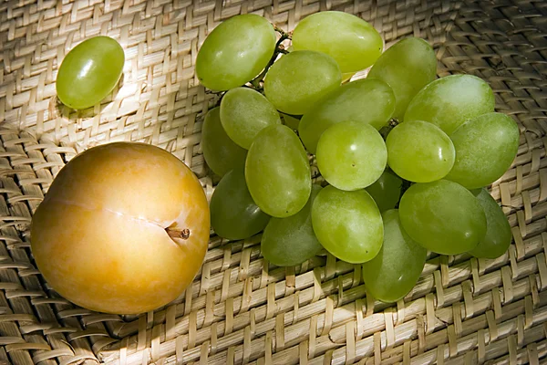 Натюрморт с виноградом и сливой — стоковое фото