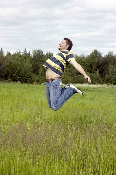 男子跳上一棵草 — 图库照片