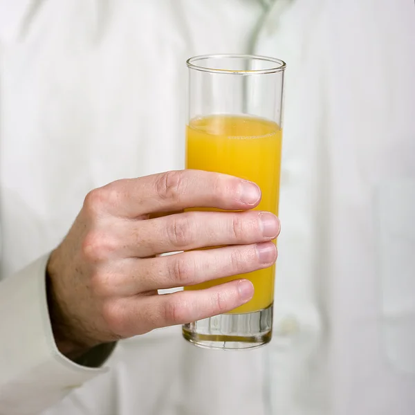 Szkło z soku pomarańczowego w rękę — Zdjęcie stockowe