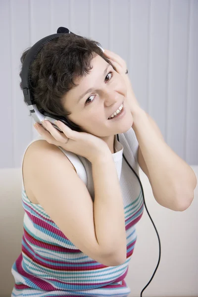 Flickan lyssnar på musik i örat-telefoner — Stockfoto