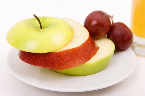 Jabłka i winogrona na talerzu — Zdjęcie stockowe