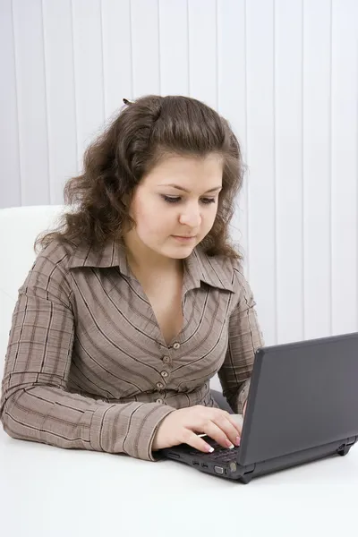 La ragazza seria con il computer portatile — Foto Stock