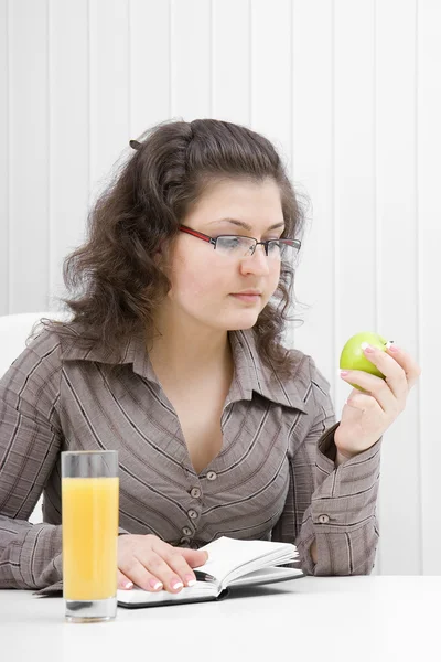 Woman with a notebook and an apple — Stock Photo, Image