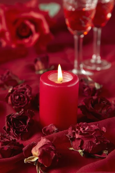 Rosas vermelhas e vela ardente — Fotografia de Stock