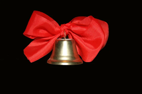 stock image Bell with red ribbons isolated on black