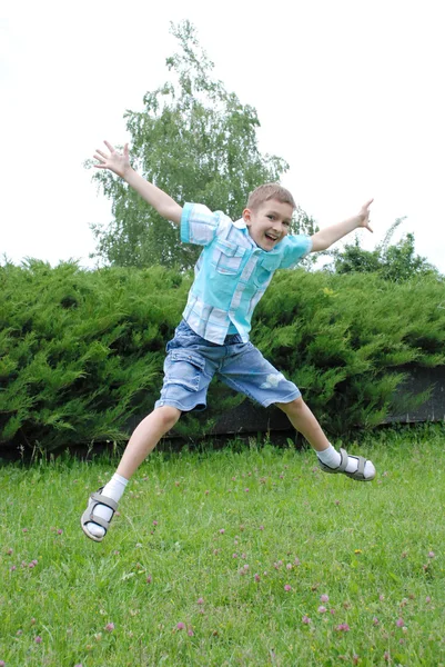 Прыгающий мальчик на зеленом фоне — стоковое фото