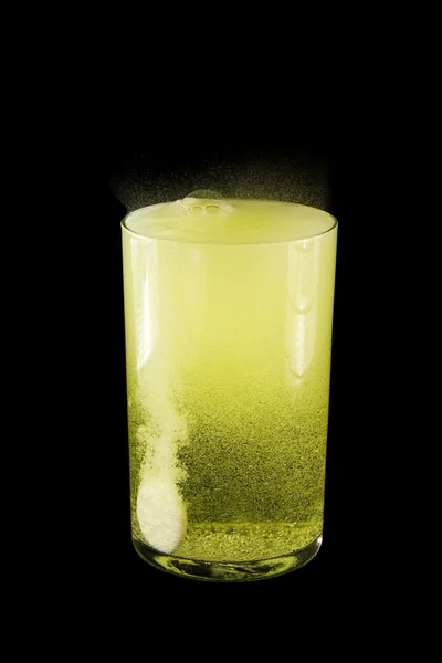 Glas mit gelbem Wasser, eine Tablette. — Stockfoto