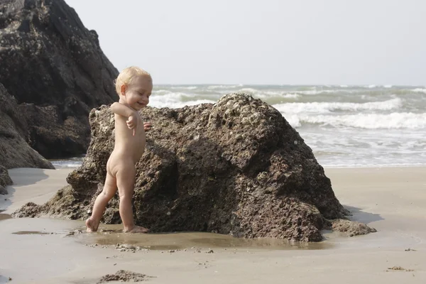 石の近くのビーチで遊んで赤ちゃん — ストック写真