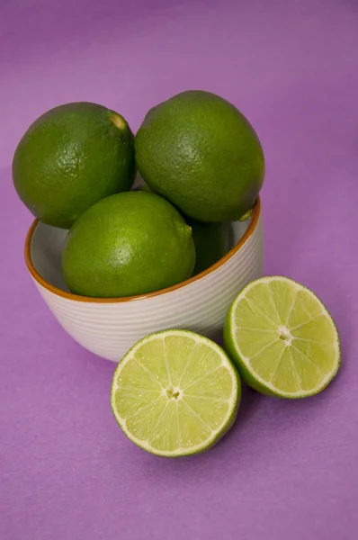 Fresh Limes on a Purple Background — Stock Photo, Image