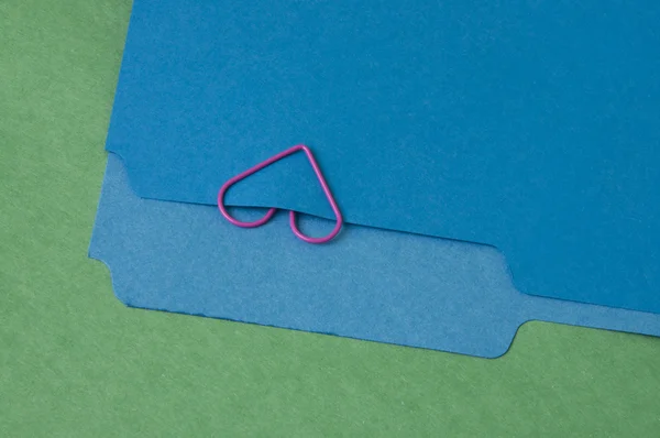 Pink Heart Paperclip em um arquivo azul — Fotografia de Stock
