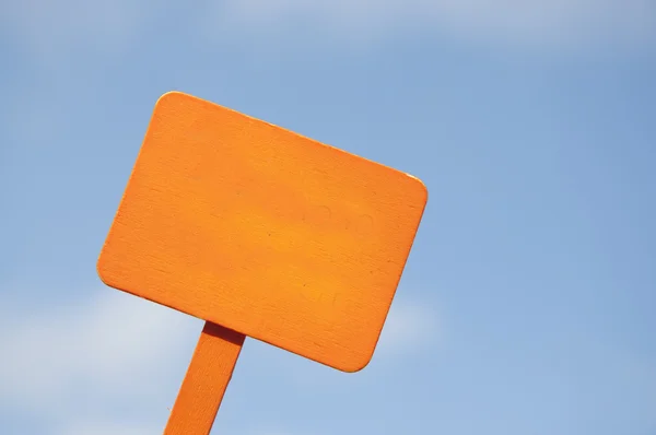 Orange skylt på ljusa blå mulen himmel — Stockfoto