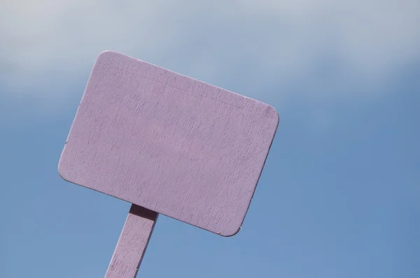 Purpurowe znak na jasny niebieski niebo pochmurne — Zdjęcie stockowe