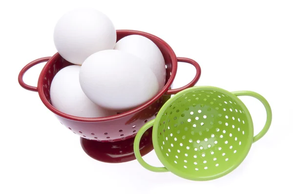 Coladores rojos y verdes con huevos frescos —  Fotos de Stock