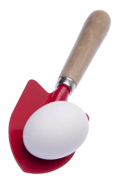 Красная лопата с яйцом, изолированным на белом — стоковое фото