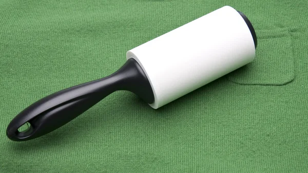 Lint Roller on a Green Sweater — Stock Photo, Image