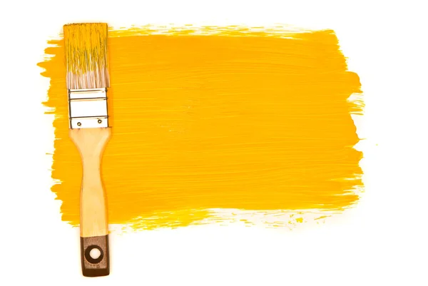Gele verf en penseel op witte studio — Stockfoto