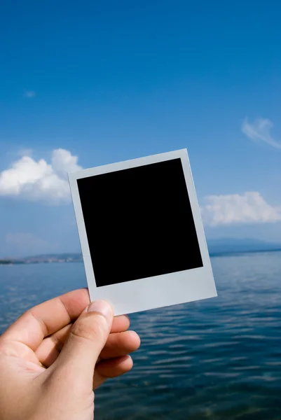 Photo in a hand on nature sea background — Stock Photo, Image