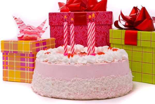 Růžový koláč se čtyřmi svíčkami a dary — Stock fotografie
