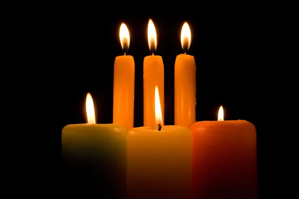 Brennende Kerzen vor schwarzem Hintergrund — Stockfoto