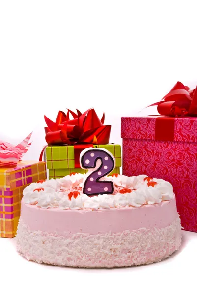 Růžový koláč s jednou svíčkou a dary — Stock fotografie